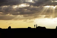 在壮观的日落天空映衬下，一对夫妇唤起一种联系和宁静的感觉