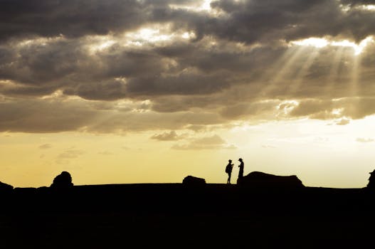 A couple silhouetted against a spectacular sunset sky, evoking a sense of connection and tranquility.