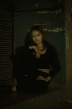 A young woman poses stylishly in an urban setting, exuding modern fashion vibes.