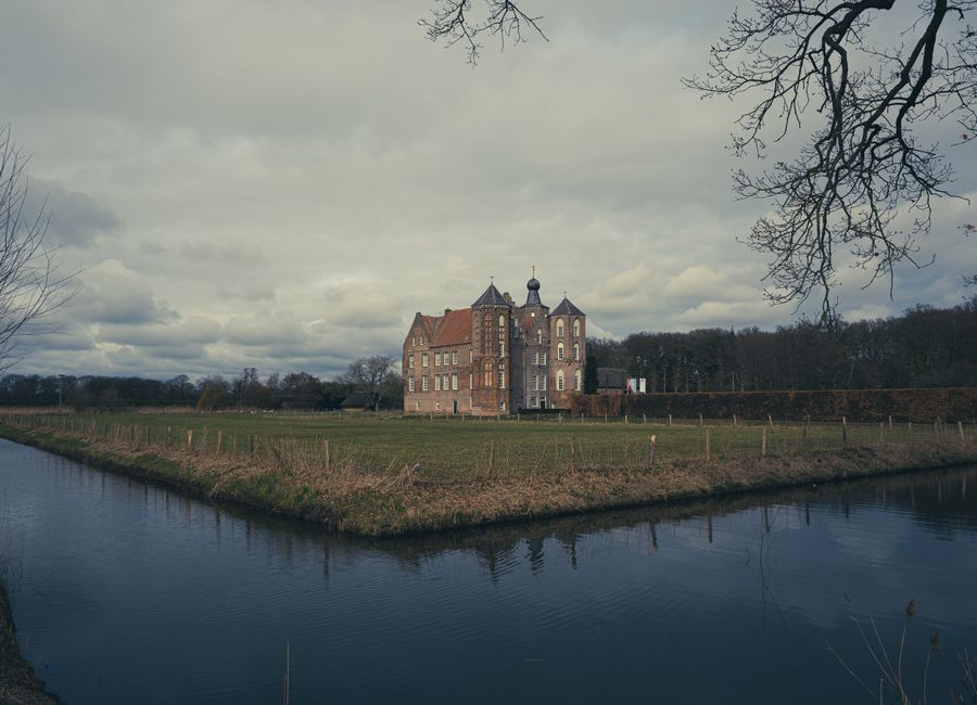 Scenic view of a historic castle in the Netherlands surrounded by a moat and rural landscape.