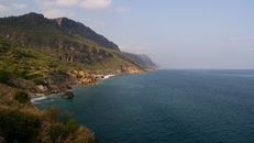 Stunning view of lush green cliffs against the deep blue ocean, perfect for travel inspiration.