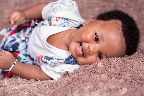 Free A Little Girl Lying on a Pink Blanket  Stock Photo