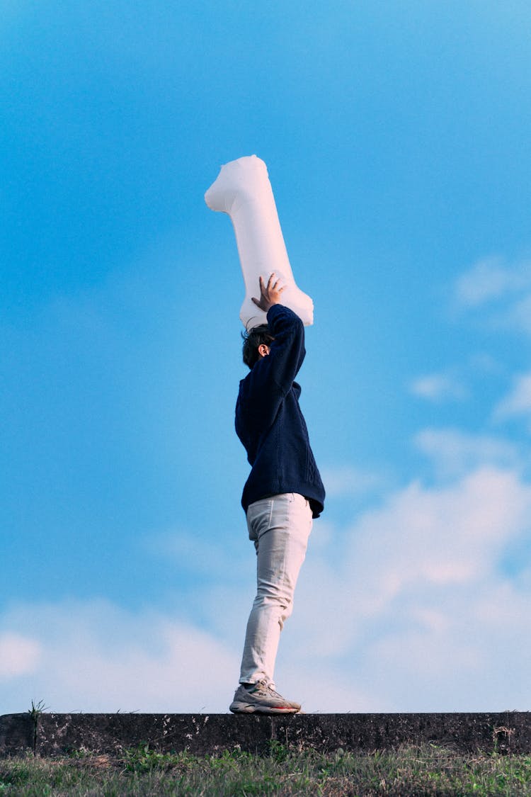 Photo Of A Man Holding A Balloon With The Number One Above His Head