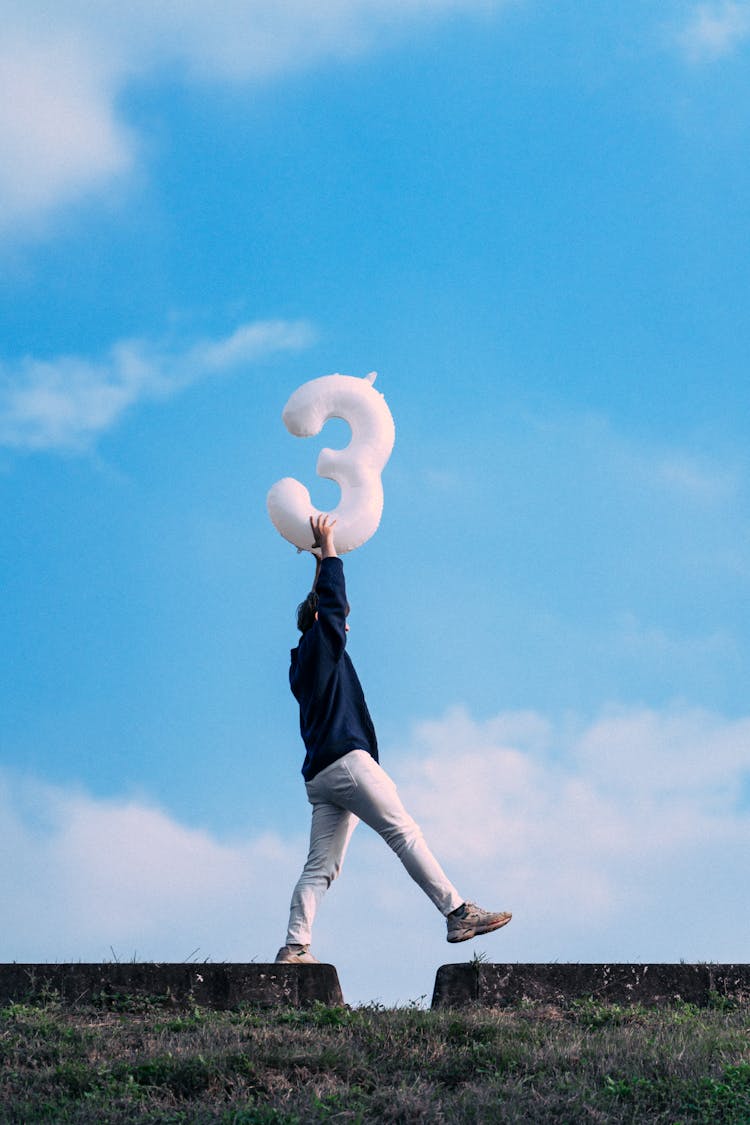 Photo Of A Man Holding A Balloon With The Number Three Above His Head