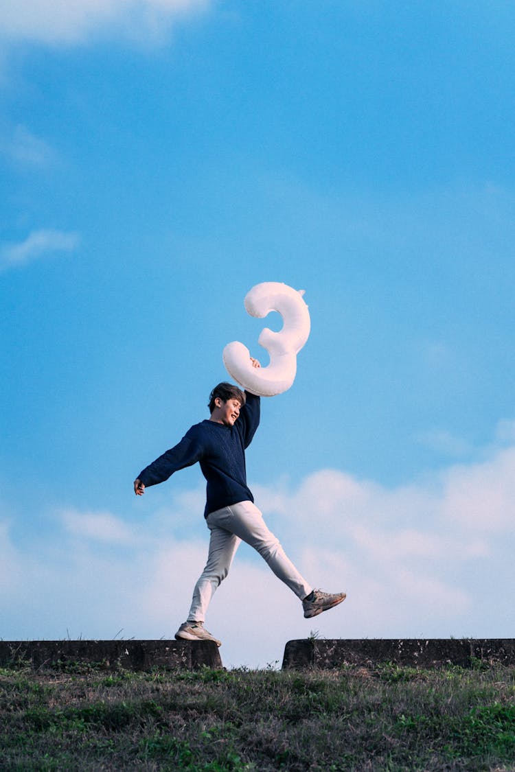 A Boy Walking With A Balloon