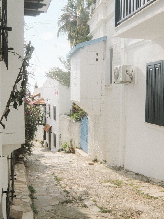 View of a Narrow Alley between White Buildings in a Greek Town 
