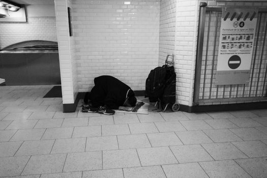 A person in prayer at a Paris subway station, suburb line 4 shutdown.