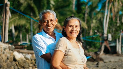Free A happy senior couple embracing and smiling at the beach, capturing love and togetherness. Stock Photo