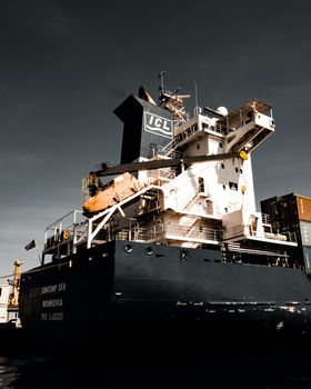 Large cargo vessel docked at Istanbul harbor under dramatic skies, showcasing global trade.