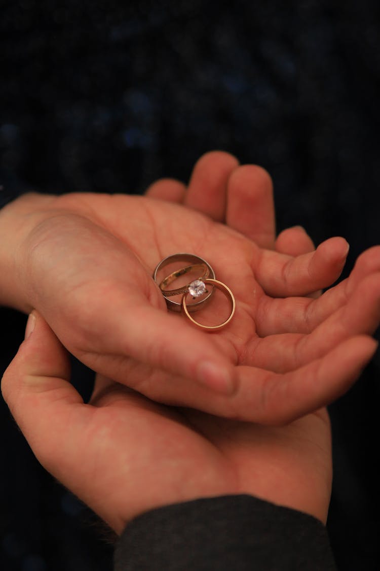 Couple Holding Wedding And Engagement Rings