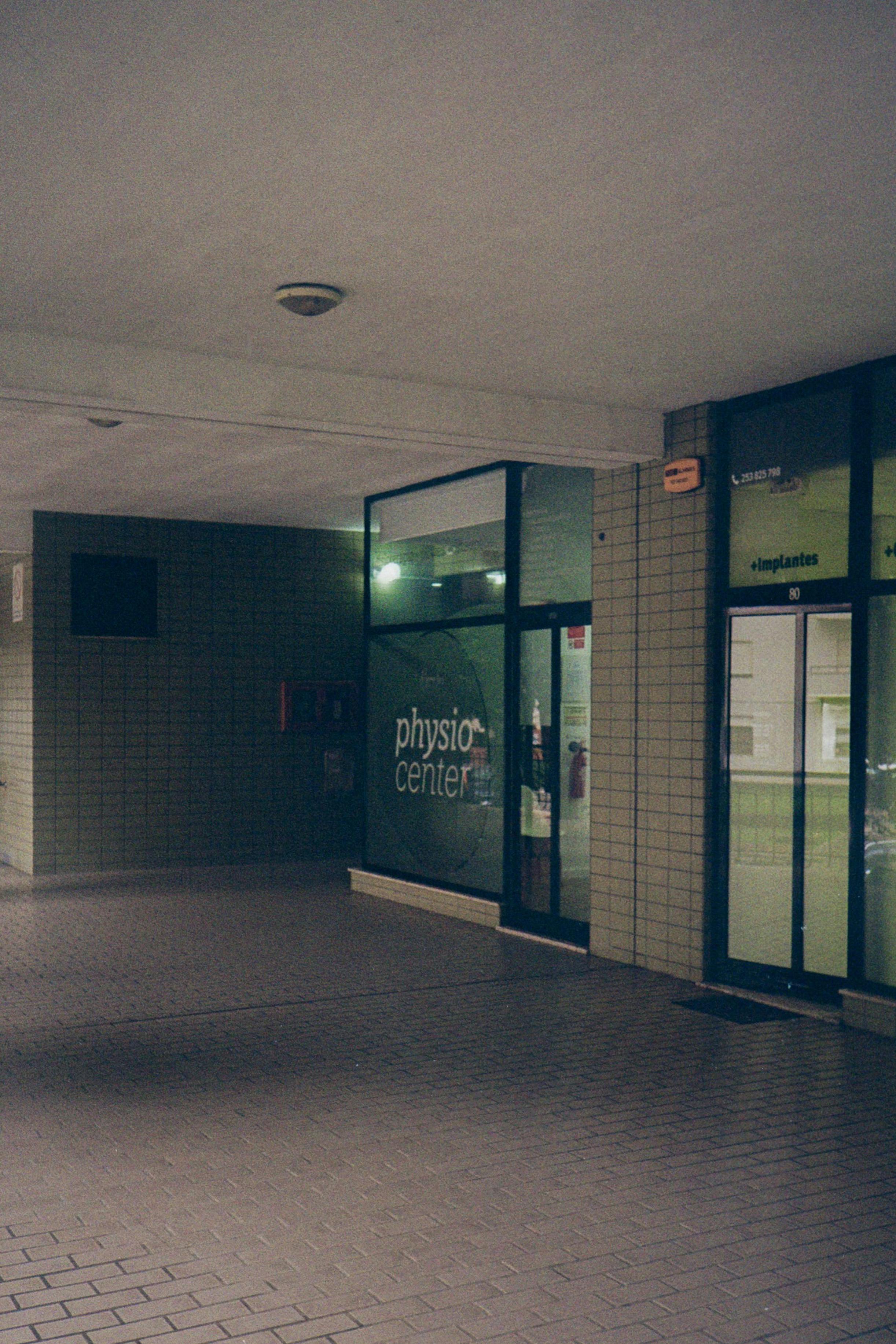 Free Dimly lit modern urban interior at physio center entrance emphasizes moody and minimalist architecture. Stock Photo