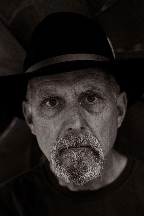 Free Stunning black and white portrait of an elderly man wearing a hat, featuring expressive eyes and a grey beard. Stock Photo