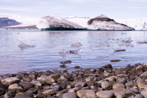 Free Calm lake with snow-capped mountains and icebergs in a serene winter landscape. Stock Photo