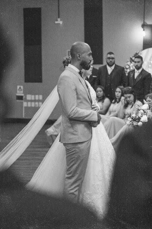 Black and White Photo of Bride and Groom Standing in Church 