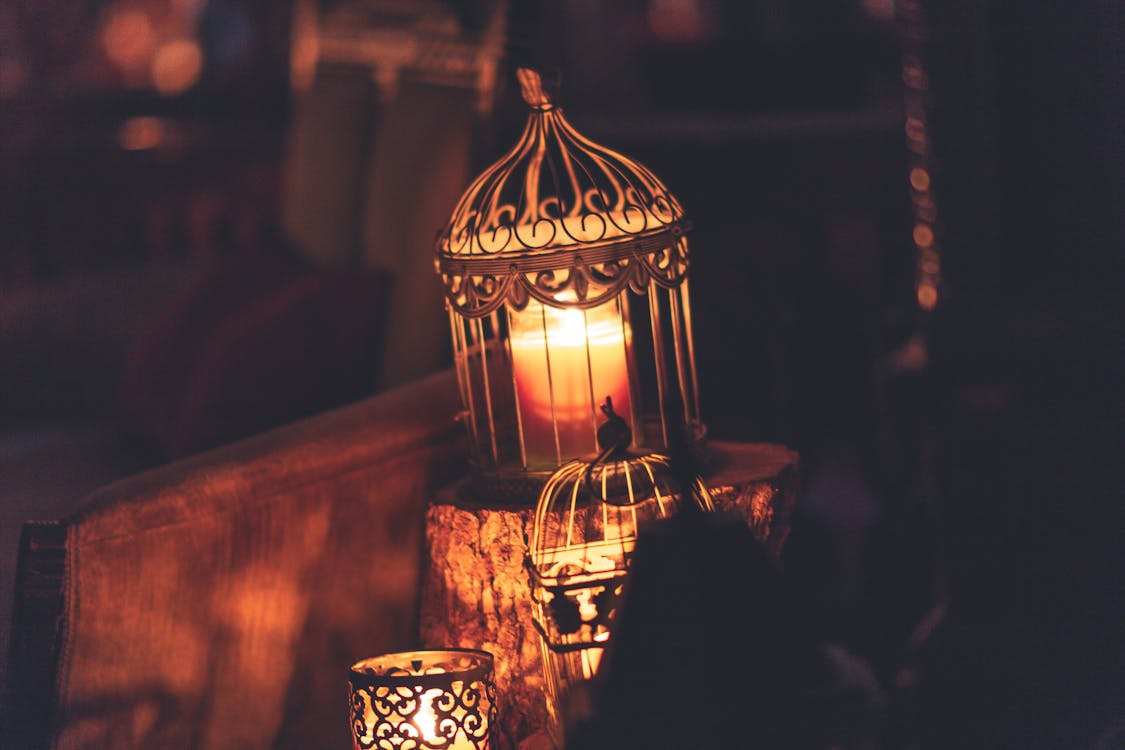 Photo Of Brown Metal Cage With Lighted Candle