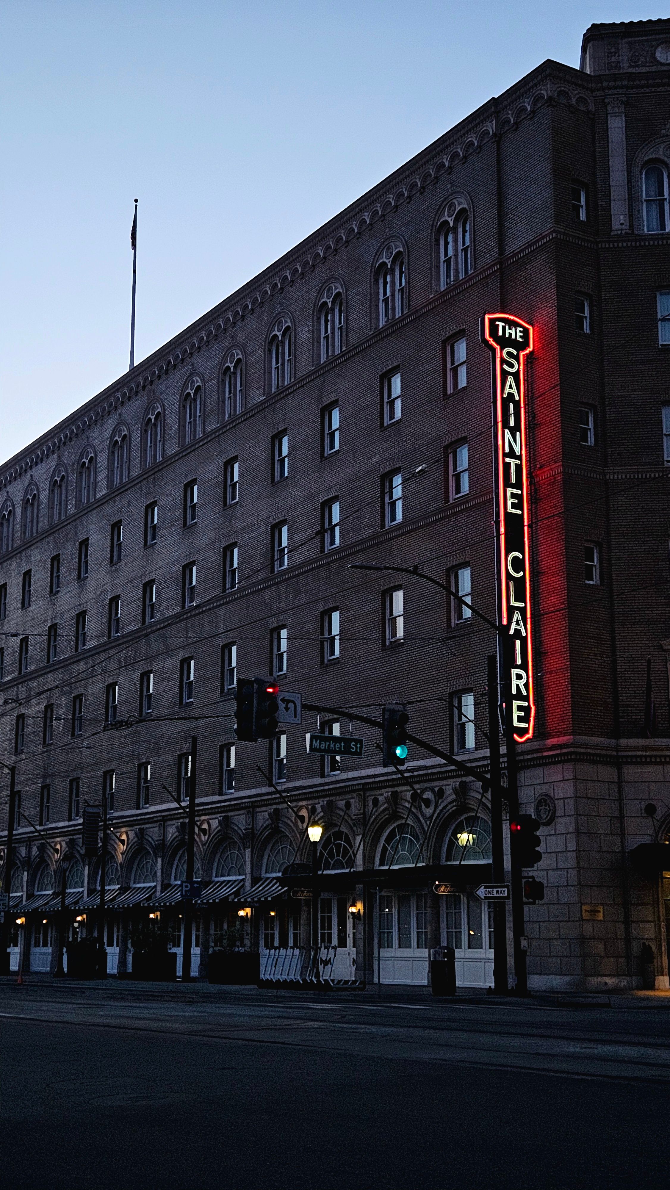 Evening view of The Sainte Claire Hotel with neon sign in San Jose, California.