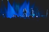 音乐会现场气氛热烈，灯光璀璨，歌手和乐队在舞台上表演