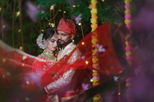 A beautiful Indian couple in traditional attire sharing an intimate moment on their wedding day.
