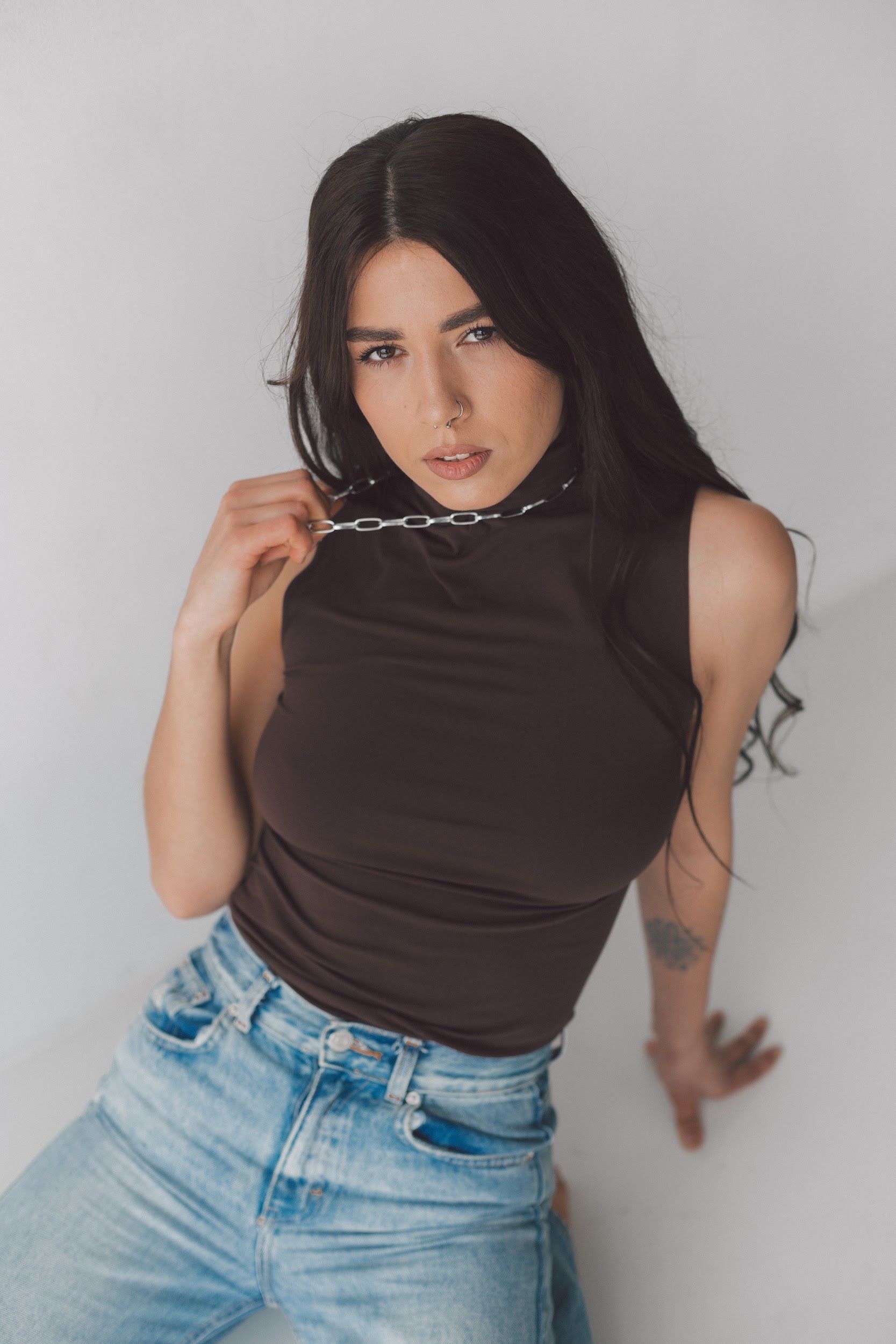 Woman in dark jeans with shell top and necklace