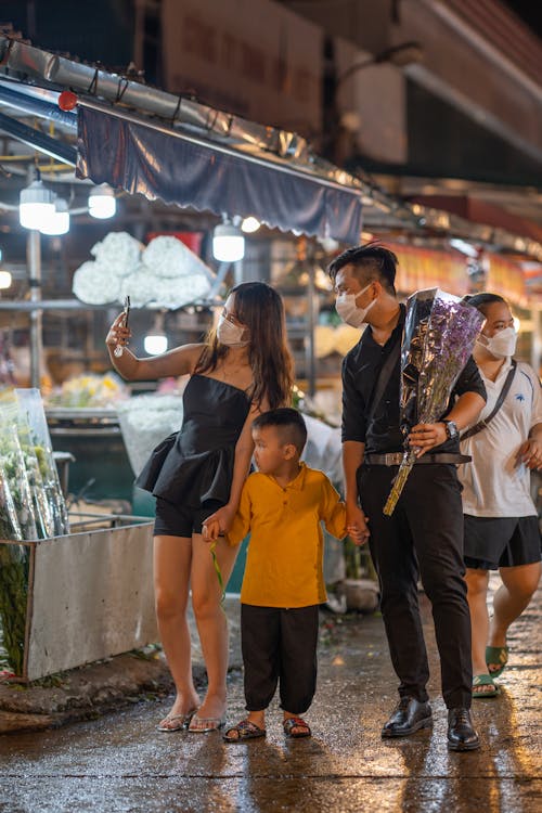 Young Family with a Son Walking in a Market and Taking a Selfie with a Smartphone 