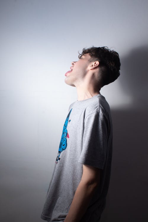 Young Man Sticking Out Tongue against a White Background