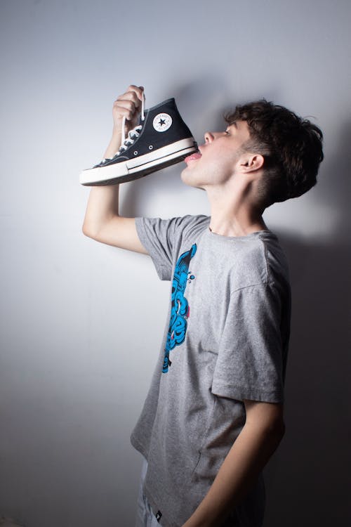 Man in T-shirt Licking Shoe