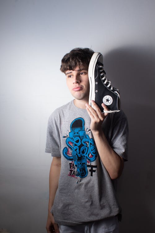 Man Posing with Shoe by Face