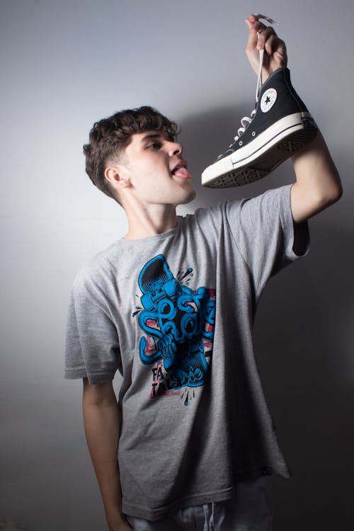 Man in T-shirt Posing with Shoe