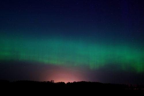 Free A mesmerizing display of the Aurora Borealis in the night sky over Ventspils, Latvia. Stock Photo