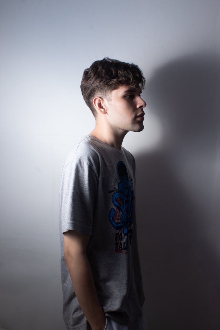 Profile Studio Shoot Of A Teenager Standing Against White Wall