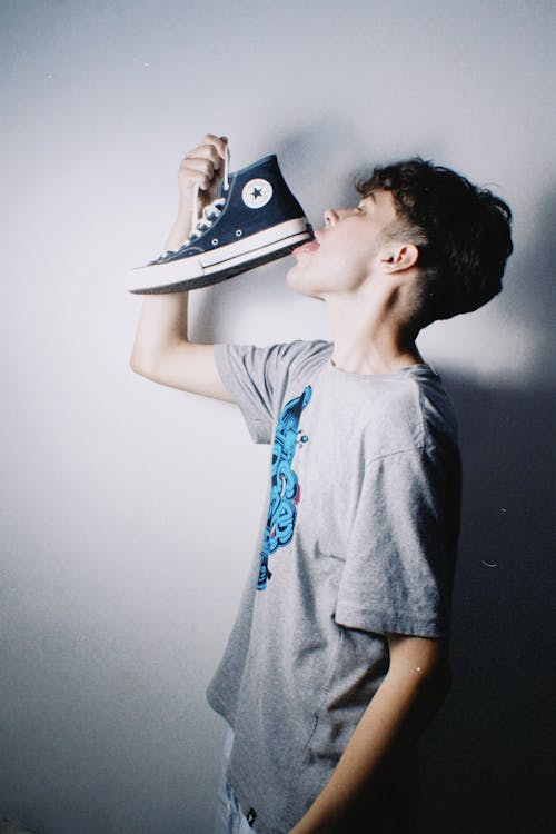Portrait of a Young Man Licking a Sneaker