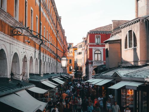 Free Bustling street market in Venice, Italy with vibrant architecture and lively crowds. Stock Photo