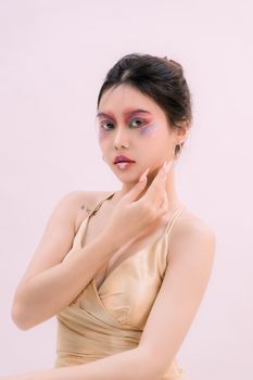 Stunning portrait of a young woman with colorful makeup and modern fashion style.