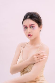 Portrait of young woman with colorful makeup in studio setting. Perfect for fashion and beauty themes.