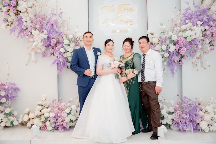 Newlyweds And Parents Posing Together On Wedding