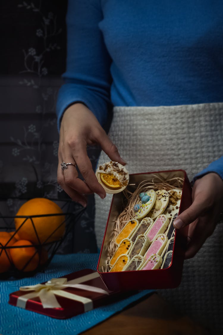 Holding Tin Box Of White Chocolate Cookies