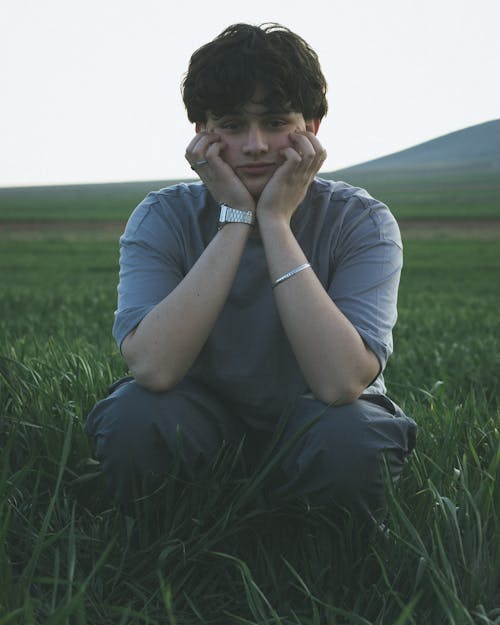 Young Man Crouching on a Meadow 