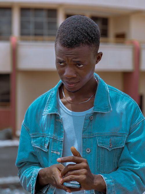 Free A fashionable young man in a denim jacket poses confidently outdoors in Nigeria. Stock Photo