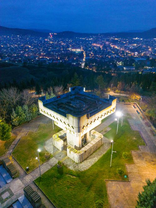 Free Captivating aerial shot of Kosturnica Monument in Kavadarci, illuminated against the night cityscape. Stock Photo