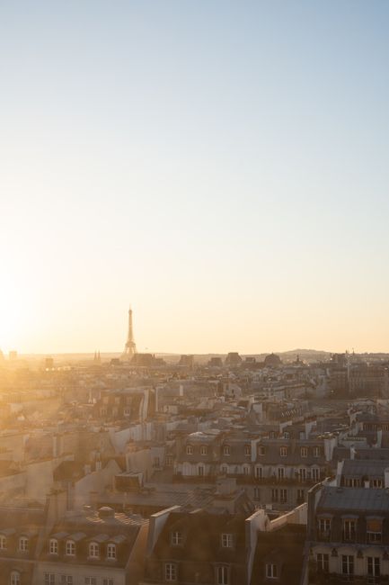 A tranquil aerial view of the Eiffel Tower at sunset, overlooking the Parisian rooftops.