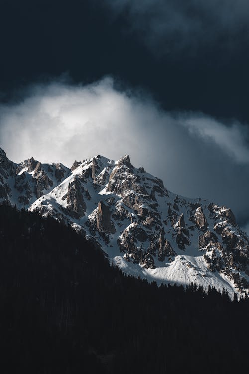 Snowcapped Mountains Against Cloudy Sky