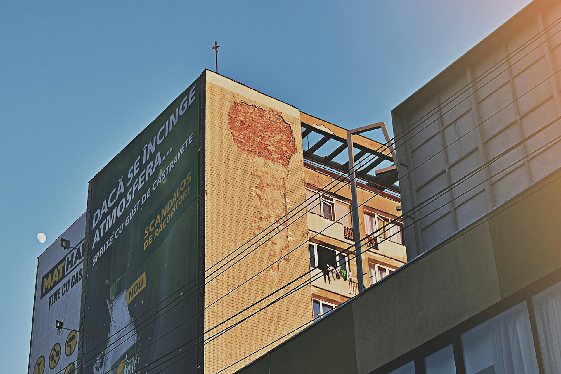 Contemporary building with a large billboard set against a clear blue sky in a city center.