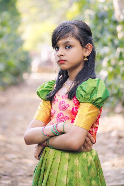 Free Portrait of a young girl in vibrant traditional clothing posing outdoors. Stock Photo