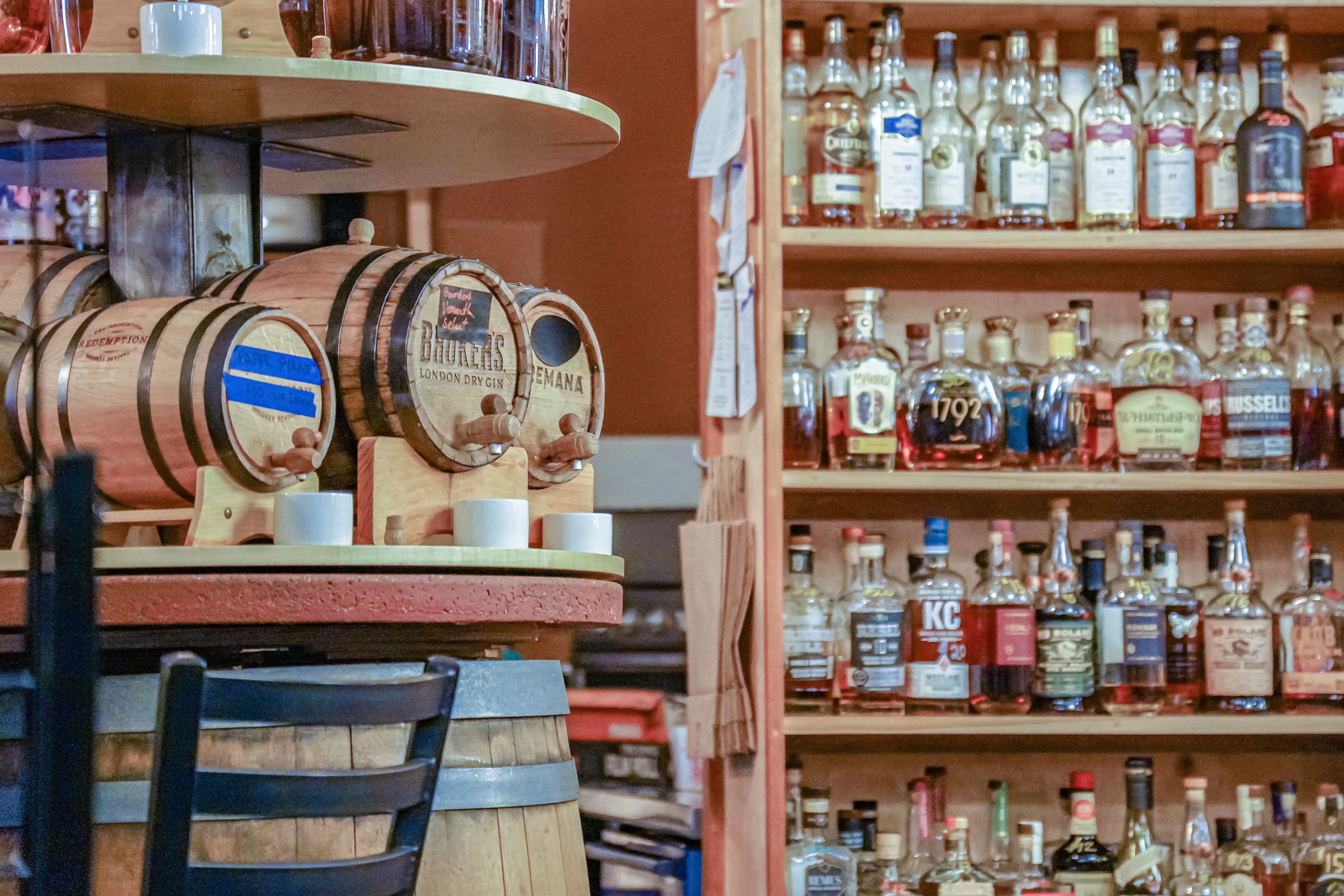 A warm bottle-shop wall with whisky and timber shelving, the sort of place where a collection gets built one bottle at a time.