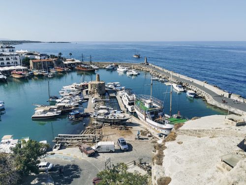 Free Aerial view of Kyrenia Harbor with boats and sea under clear blue skies. Stock Photo