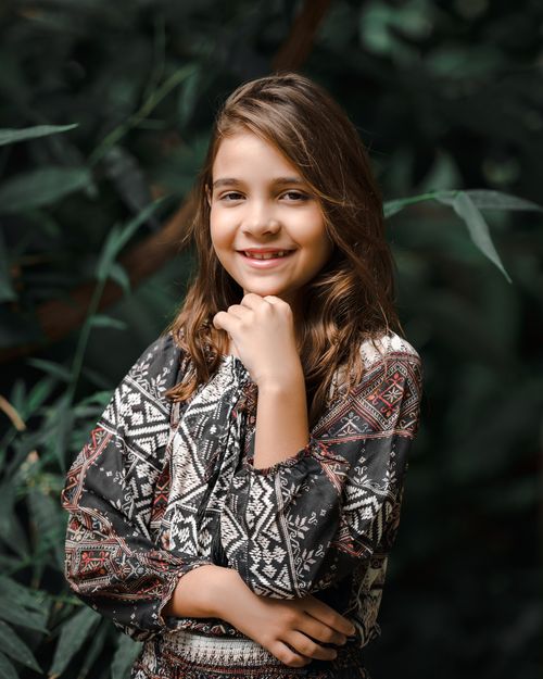 Free A young girl smiles while posing outdoors, showcasing natural beauty and fashion. Stock Photo