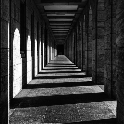 Free Dramatic black and white image of a colonnade casting intricate shadows in Weimar, Germany. Stock Photo