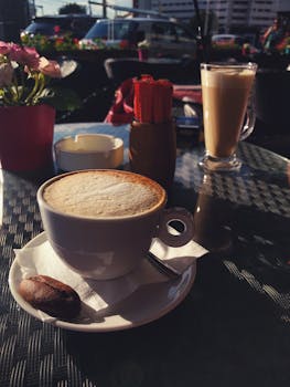 Enjoy a delicious cappuccino and latte at an outdoor café table on a sunny day in Iași.