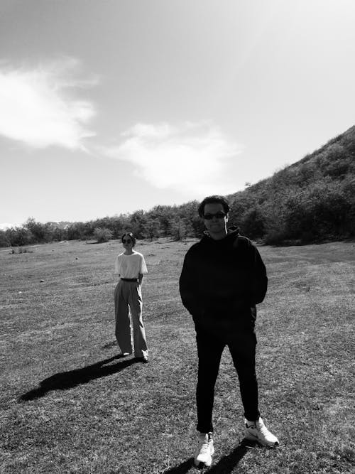 Man and Woman Posing on Sunlit Meadow in Black and White