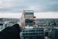 一个人在全景城市景观中用智能手机捕捉埃菲尔铁塔